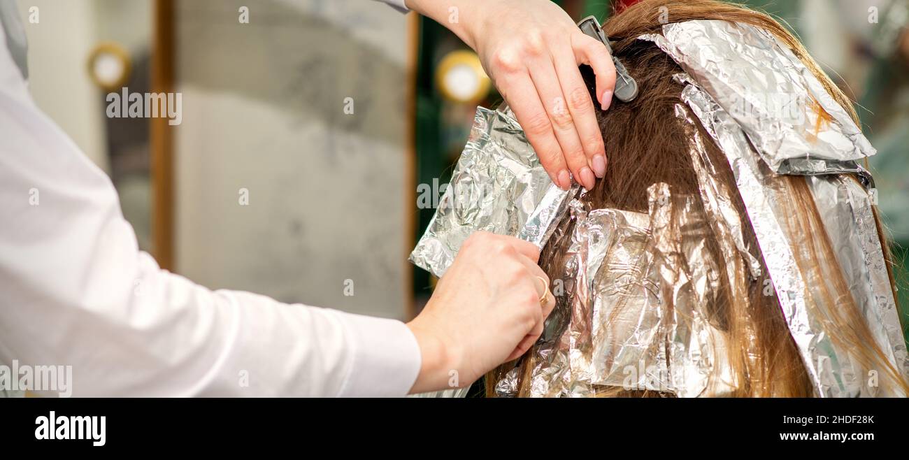 https://c8.alamy.com/comp/2HDF28K/hands-of-hairdresser-dying-hair-applying-foil-for-a-brunette-woman-at-the-hairdressing-salon-close-up-2HDF28K.jpg