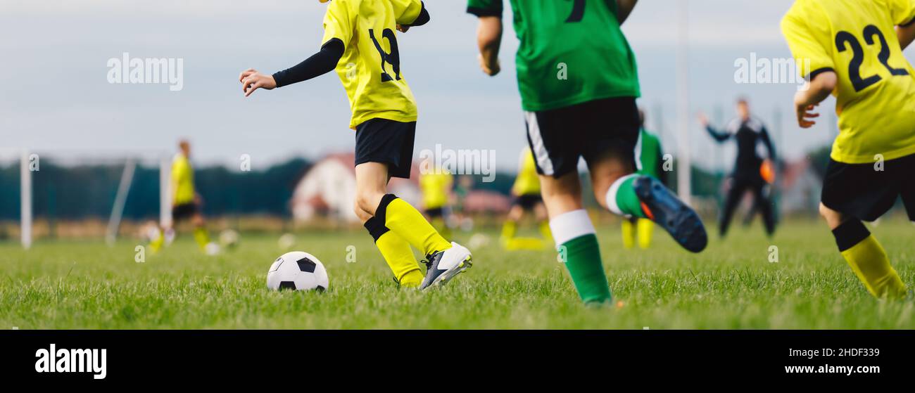 Football Players Running Classic Soccer Ball on Natural Grass Field. Soccer Summer Traing Camp For School Kids Stock Photo
