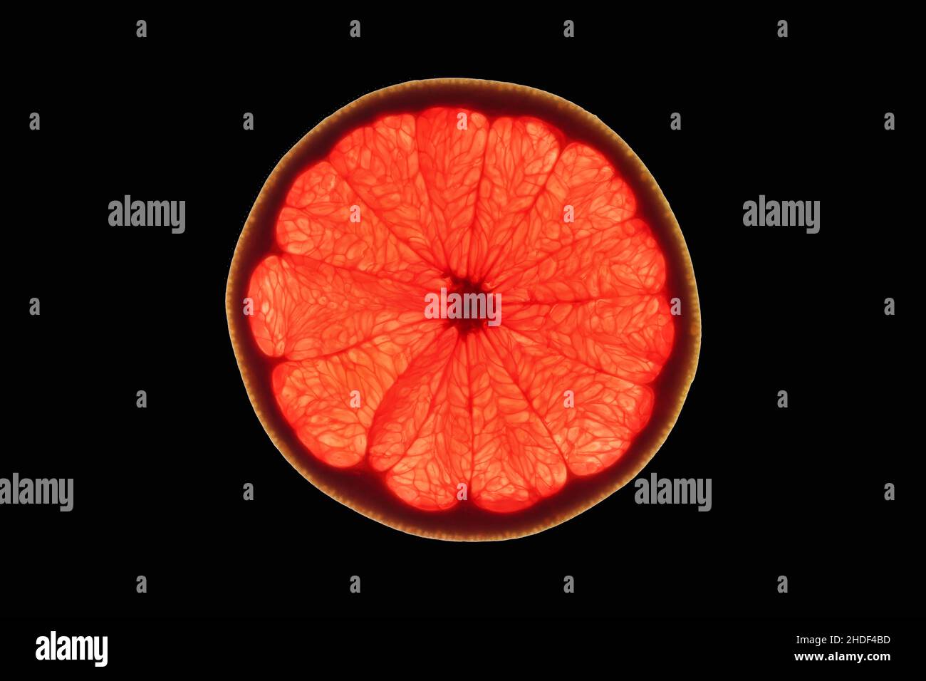 Slice of ripe ruby grapefruit on black background Stock Photo