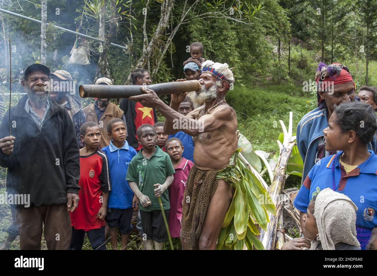 Papua New Guinea; Eastern Highlands Goroka; An almost naked Papuan drinks  water from a bamboo vessel. Nackte Papua trinkt Wasser aus einem  Bambusgefäß Stock Photo - Alamy