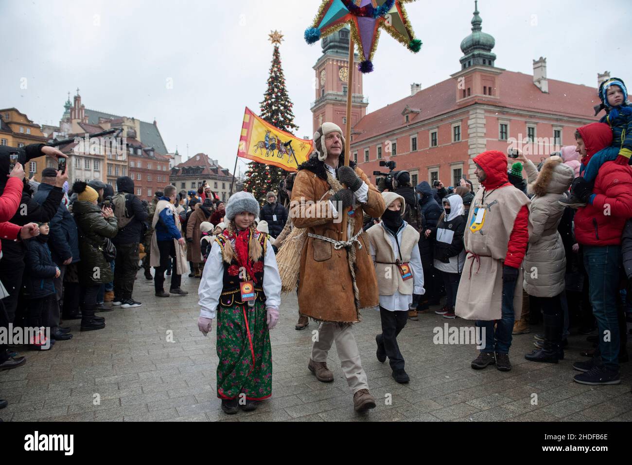 Warsaw, Warsaw, Poland:January 6, 2022, A man surrounded by children dressed in traditional clothes carries a star during the Epiphany celebration on January 6, 2022 in Warsaw, Poland. Several hundreds of people gathered in the old town to celebrate Epiphany, also known as Three Kings Day in Poland, despite the rising number of Sars-CoV2 (Coronavirus) infections. (Credit Image: © Aleksander Kalka/ZUMA Press Wire) Stock Photo