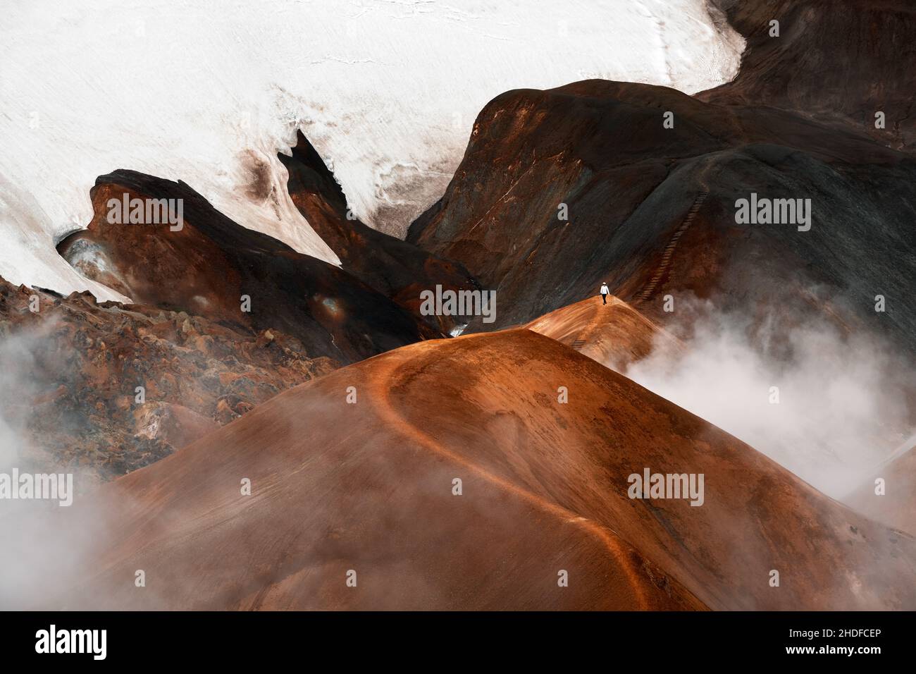 Hiker crossing colourful mountains in the geothermal area of Kerlingarfjöll. Stock Photo