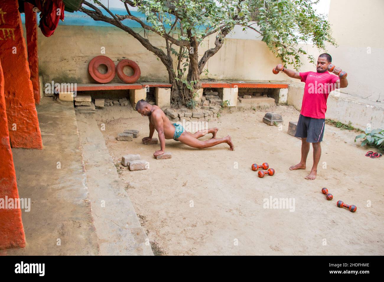 Unidentified Indian wrestlers do exercise by lifting their traditional equipments near ganga Ghat in Varanasi, Uttar Pradesh, India. Stock Photo