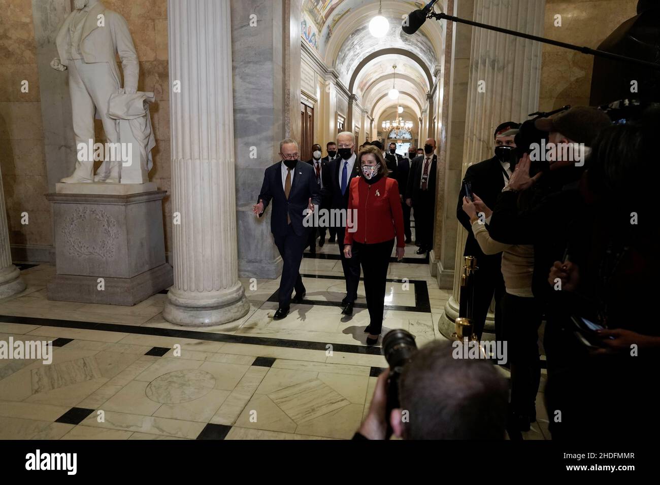 U.S. President Joe Biden joined by Senate Majority Leader Chuck Schumer (D-NY) and U.S. House Speaker Nancy Pelosi (D-CA) walk through the Hall of Columns before speaking during a ceremony on the first anniversary of the January 6, 2021 attack on the U.S. Capitol by supporters of former President Donald Trump in Washington, D.C., U.S., January 6, 2022. Ken Cedeno/Pool via REUTERS Stock Photo