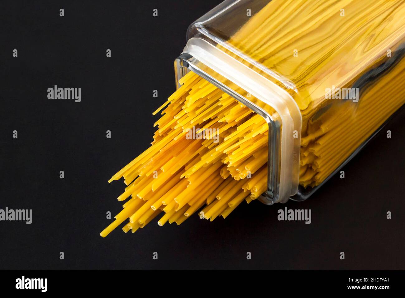 Uncooked,dry various sizes of spaghetti pasta in long glass jar on