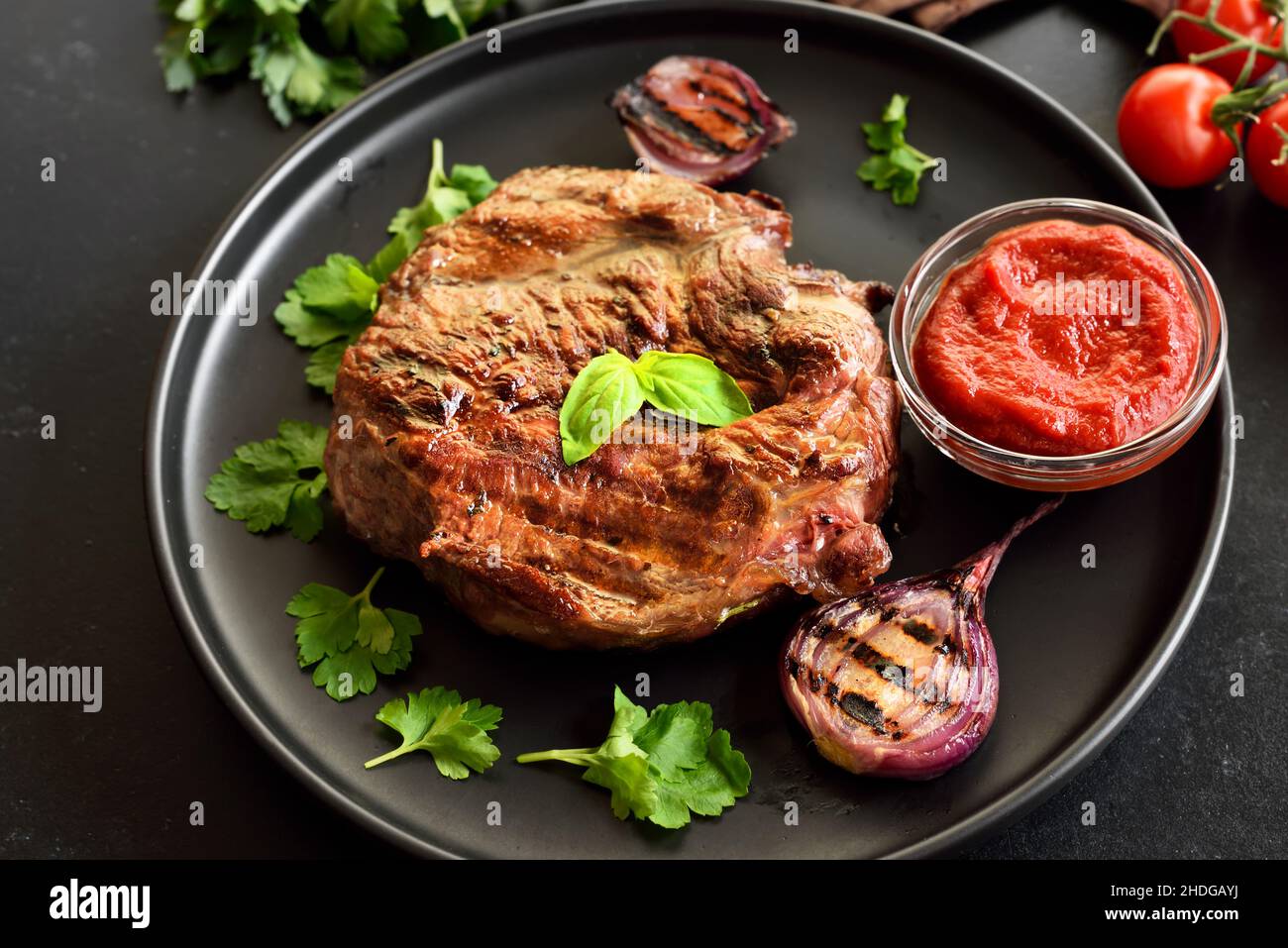 Juicy grilled beef steak and tomato sauce on plate Stock Photo