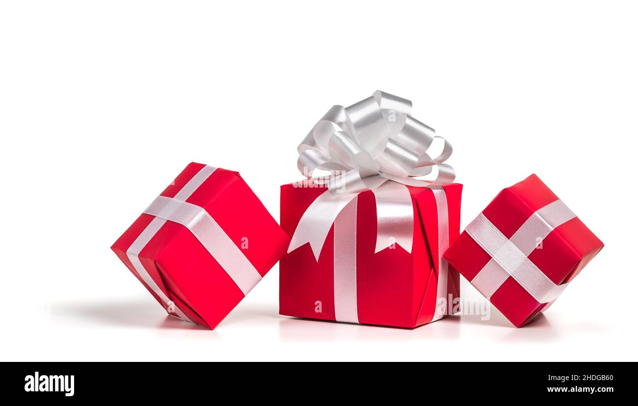 Red gift boxes with silver bow on a white background. Stock Photo