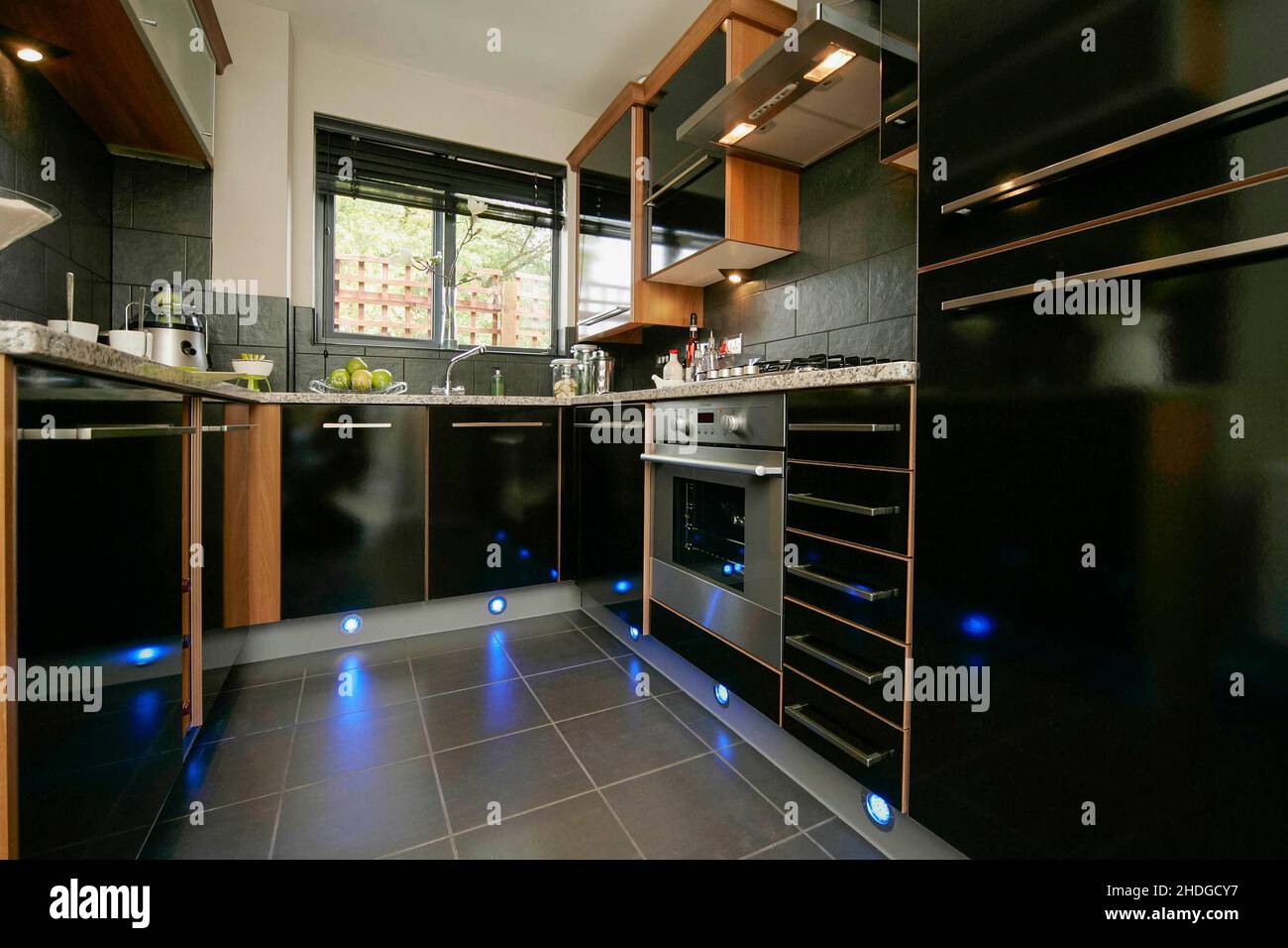 Modern small kitchen,black units,quartz worktop,plinth lighting,floor