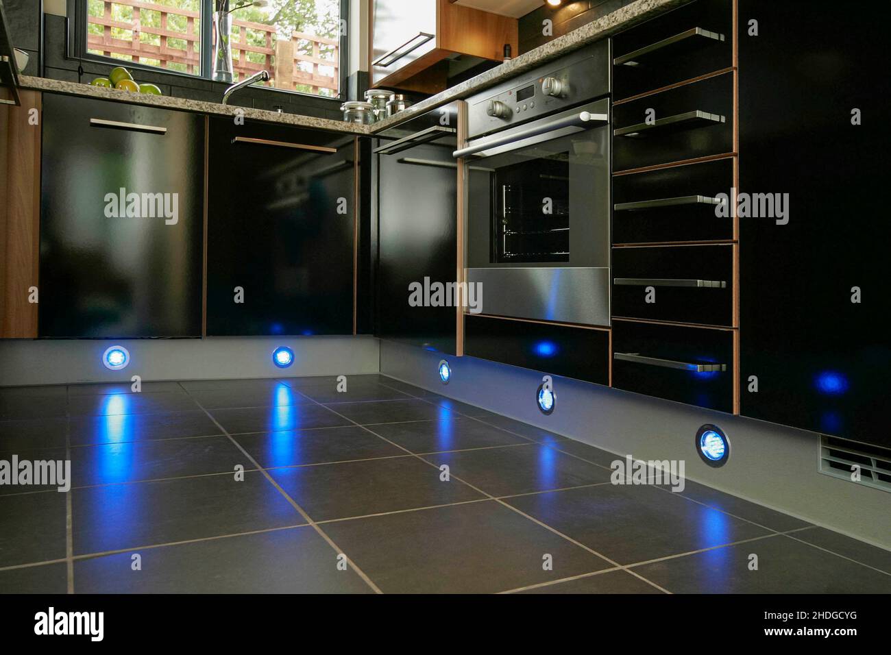 Modern small kitchen,black units,quartz worktop,plinth lighting,floor