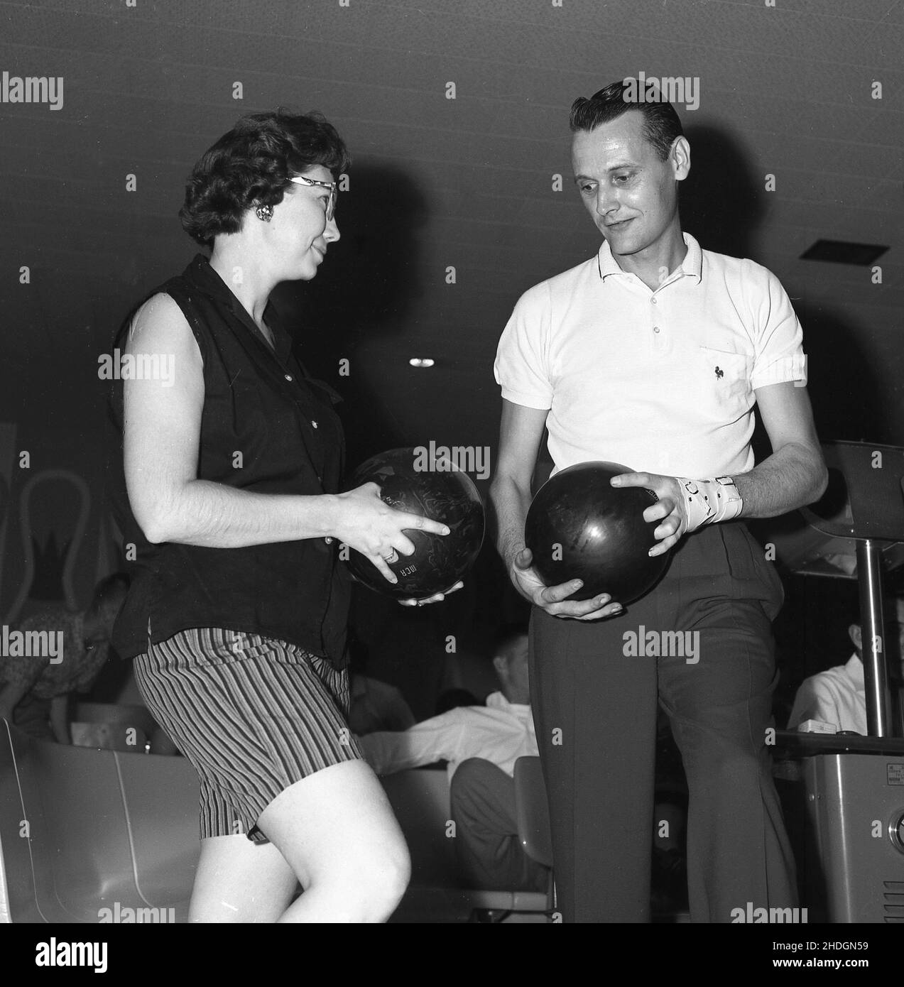 1960, historical, ten-pin bowlers, man and woman holding their balls, with the woman using two fingers and her thumb in the three holes, Columbus, Ohio, USA. In the 1950s and 60s, a popular lesiure pastime in the USA, ten-pin was also a competitive amateur sport, with an organised, competitive league structure, with both men and women teams. In 1958 the Professional Bowlers Association (PBA) was formed. Stock Photo