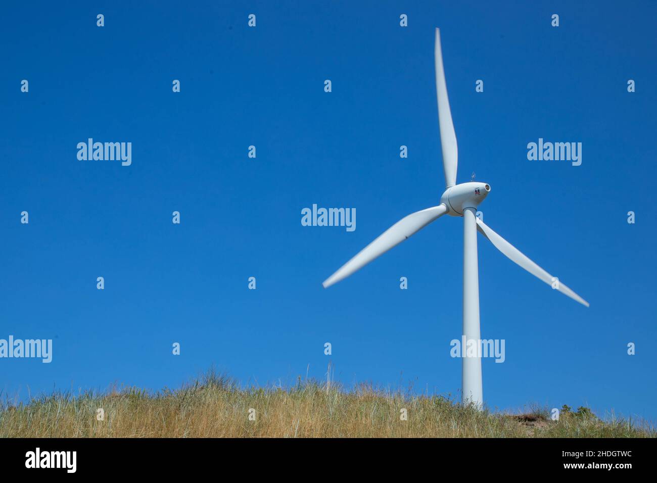 Windmill for electricity generation the background of a blue sky. Stock Photo