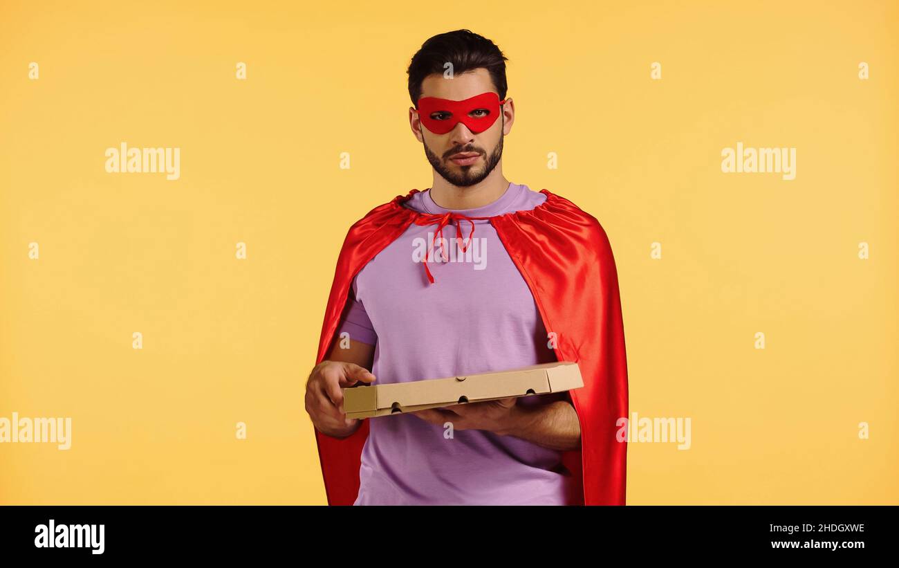 bearded man in superhero costume holding pizza box isolated on yellow Stock  Photo - Alamy