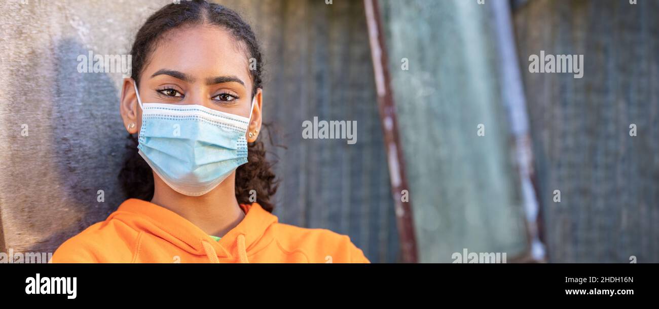 Girl teenager teen mixed race biracial African American female young woman wearing face mask in Coronavirus COVID-19 pandemic panoramic web banner hea Stock Photo