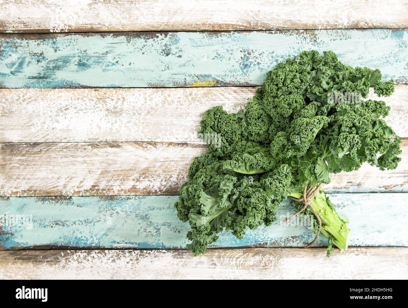 Kale green vegetable cabbage leaves on wooden background. Organic food Stock Photo