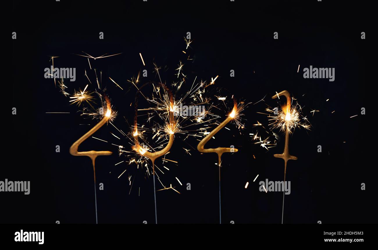 Goodbye 2021! Burning sparklers decoration on dark background Stock Photo