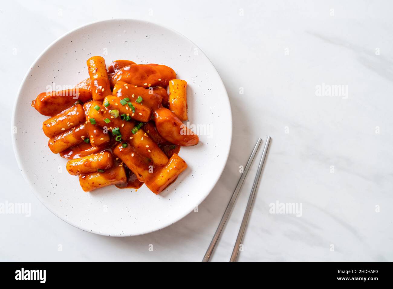 Korean rice cake stick with sausage in spicy sauce (Tteokbokki