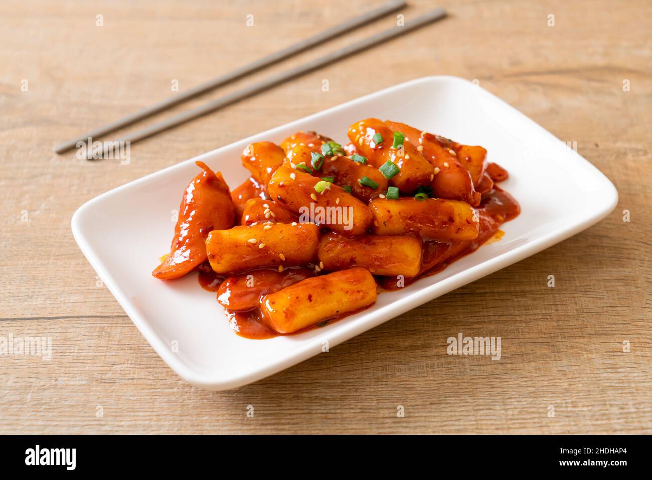 Korean rice cake stick with sausage in spicy sauce (Tteokbokki