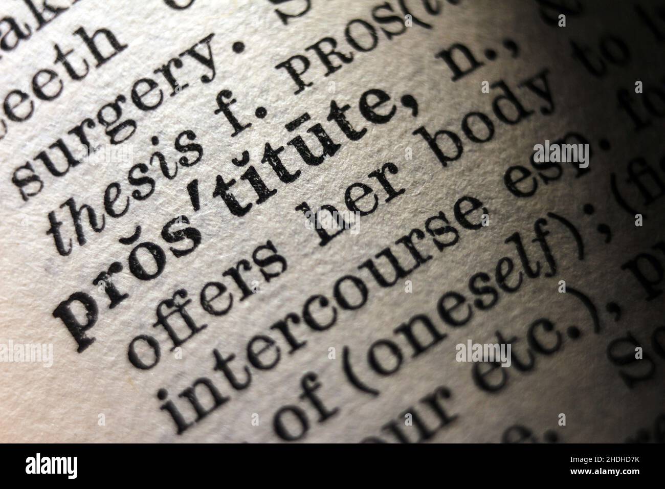 Word 'prostitute' printed on dictionary page, macro close-up Stock Photo