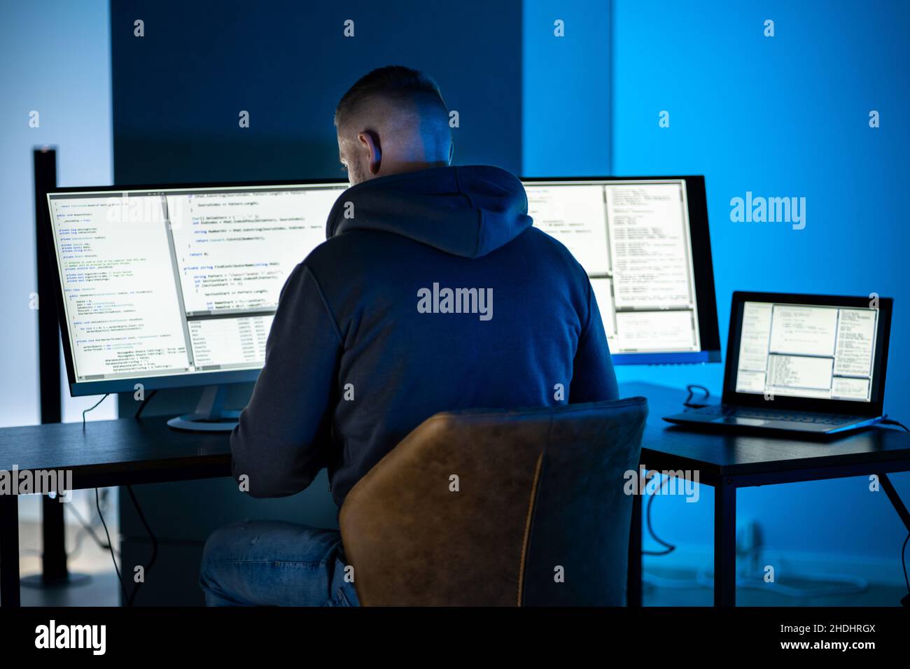 Hacker Using Computer To Write Cyber Security Exploit Software Program Stock Photo