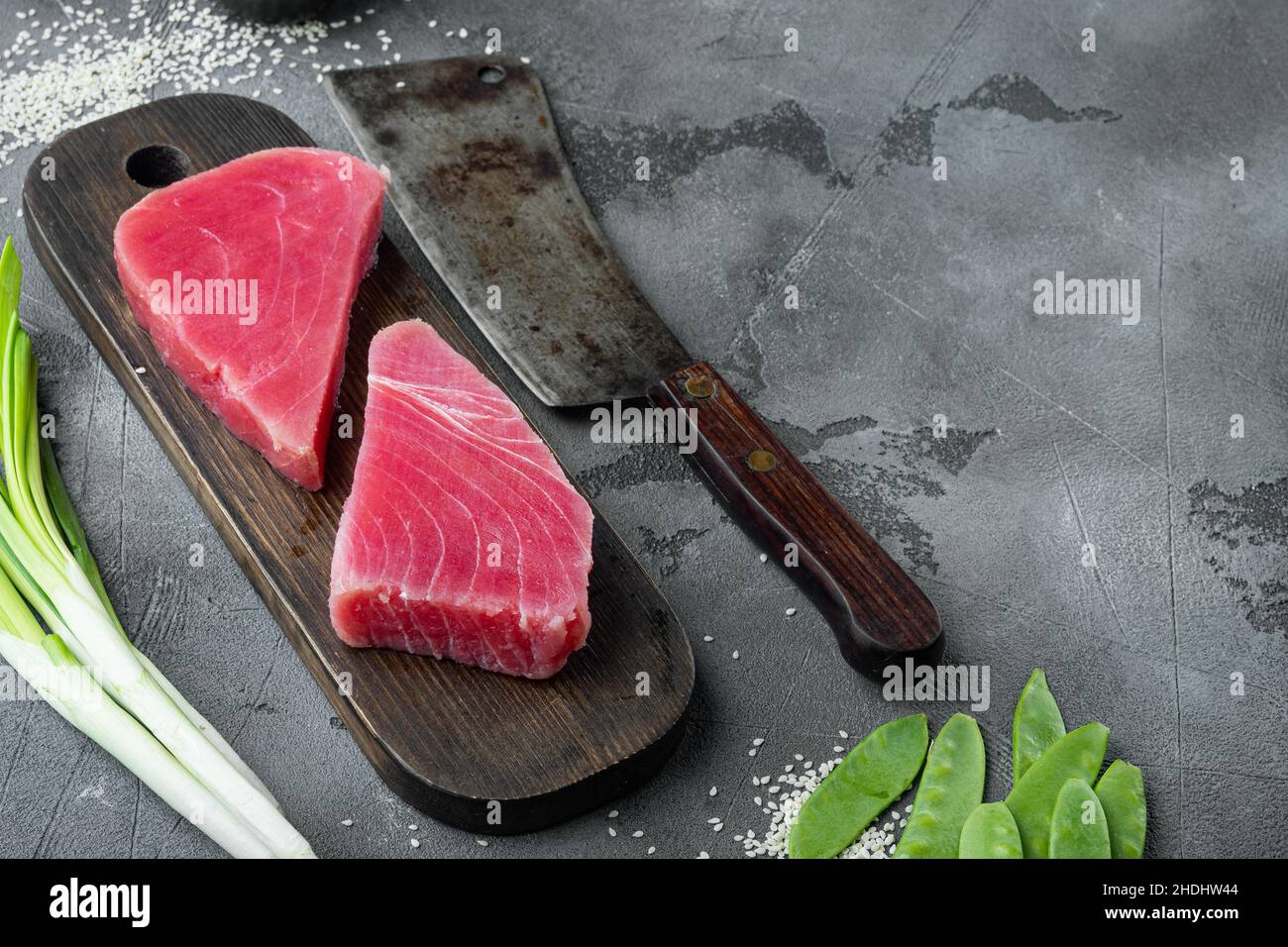 Premium Photo  Raw tuna steak, fresh red tuna fish fillet set, on wooden  cutting board, and old butcher cleaver knife, on gray stone