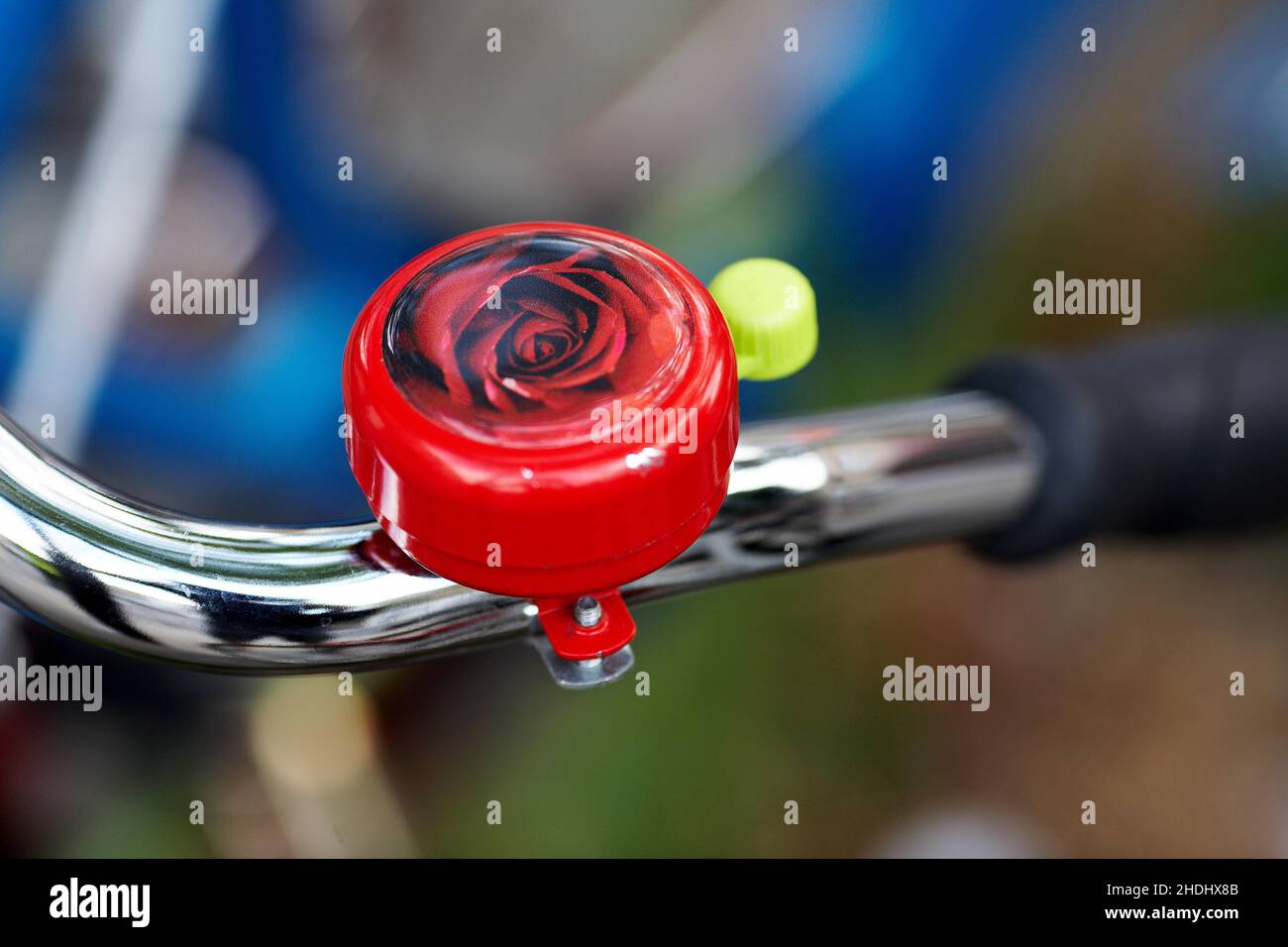 Rose bicycle bell .Bicycle handlebar with bell with blurred background. Stock Photo