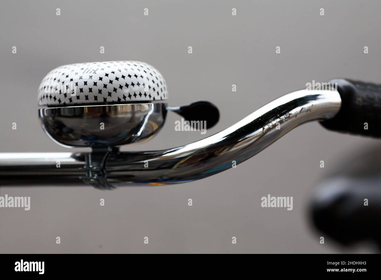 Polkadot bicycle bell . Bicycle handlebar with bell with blurred background. Stock Photo