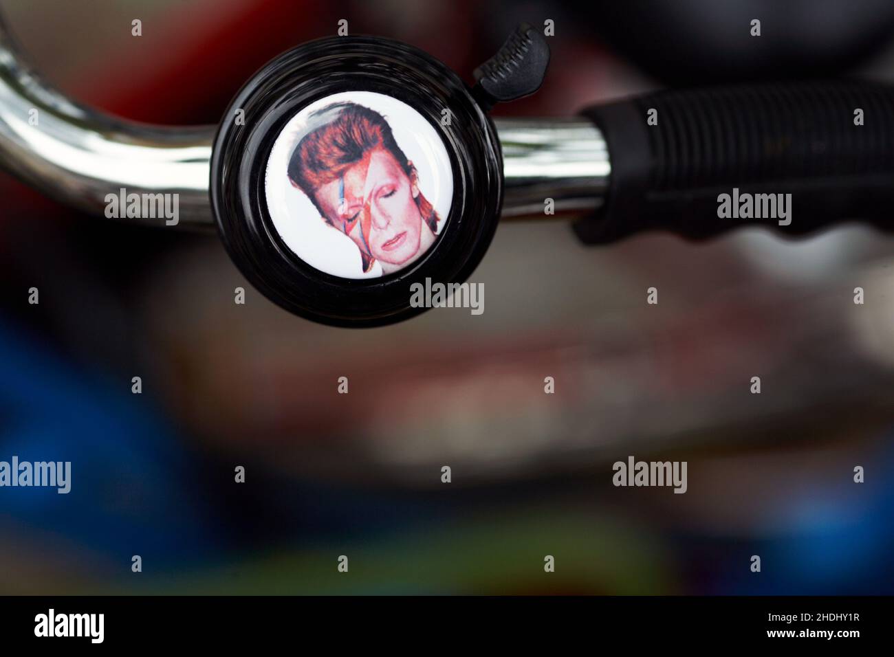 David Bowie – Ziggy Stardust bicycle bell .Bicycle handlebar with bell with blurred background. Stock Photo