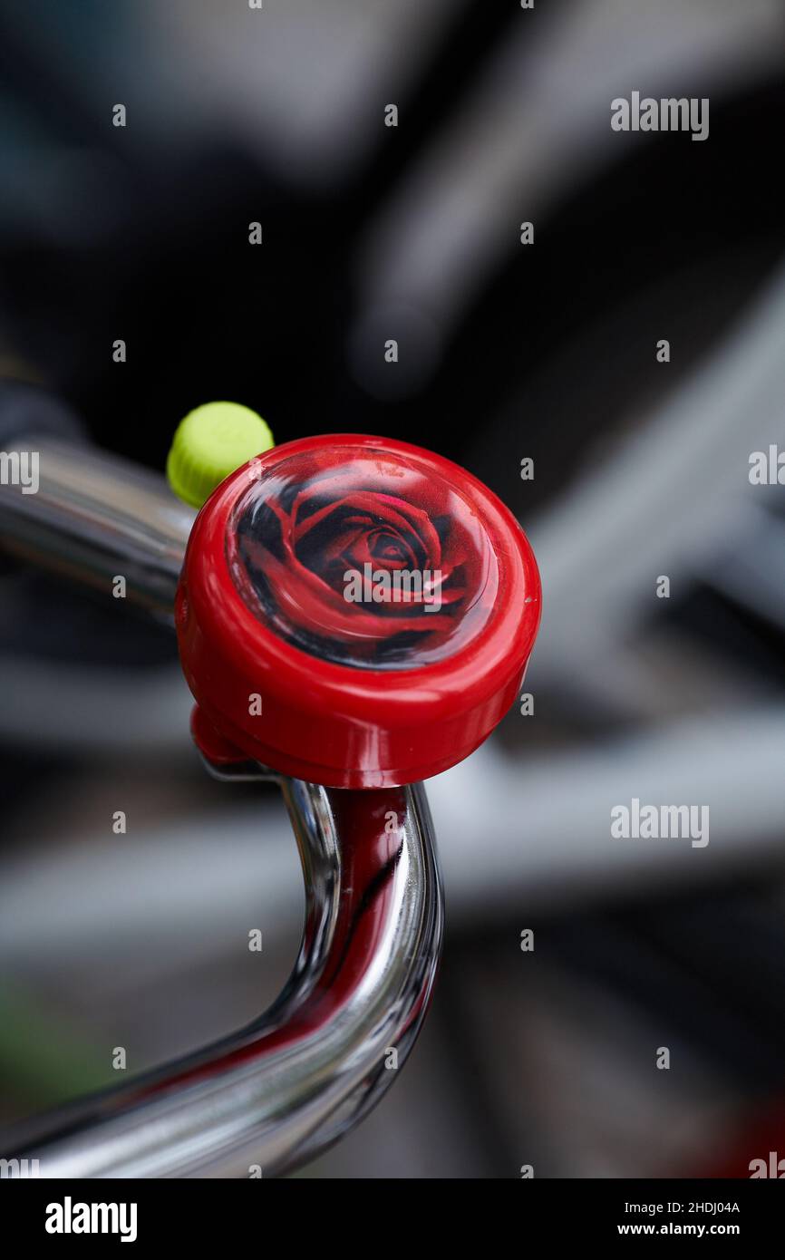 Rose bicycle bell .Bicycle handlebar with bell with blurred background. Stock Photo