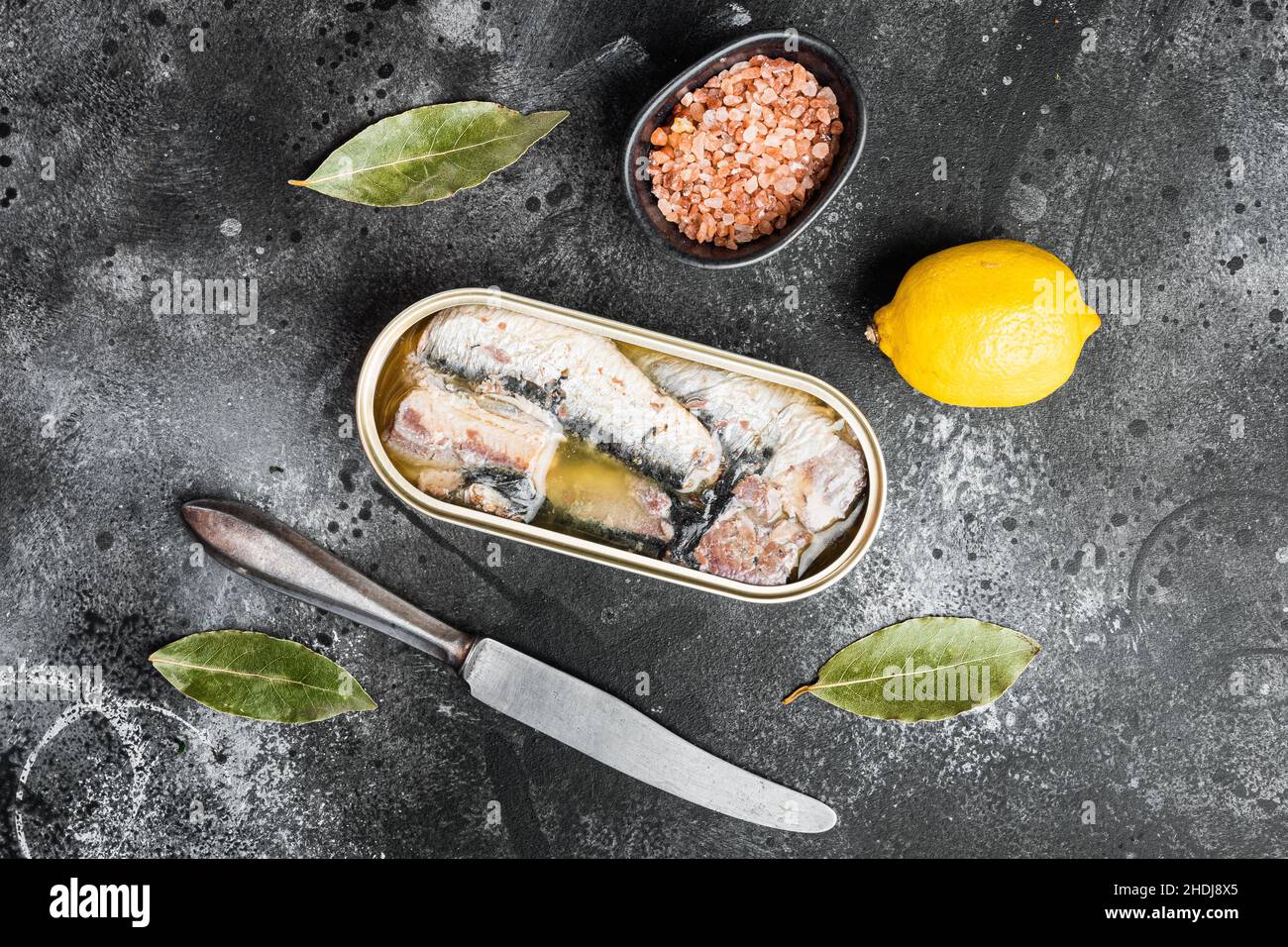 Canned sardine in oil set, on black dark stone table background, top