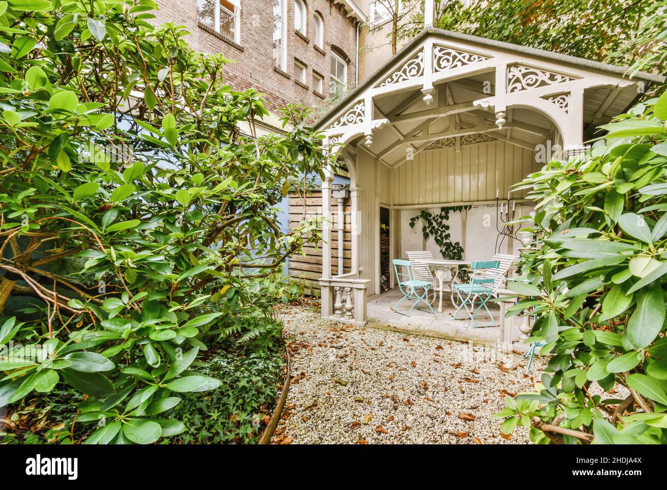 Cozy courtyard of the house with green trees and bushes and a white ...