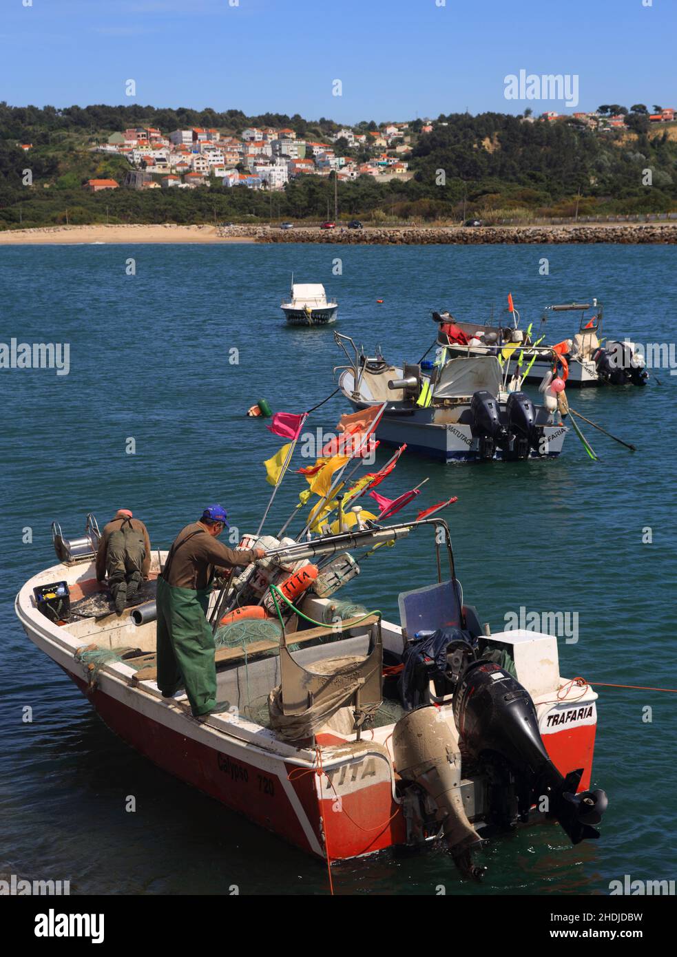 A crew of coastal fishermen prepare their boat for sea in the tiny port of Traferia, on the Tagus River estuary. On April Stock Photo