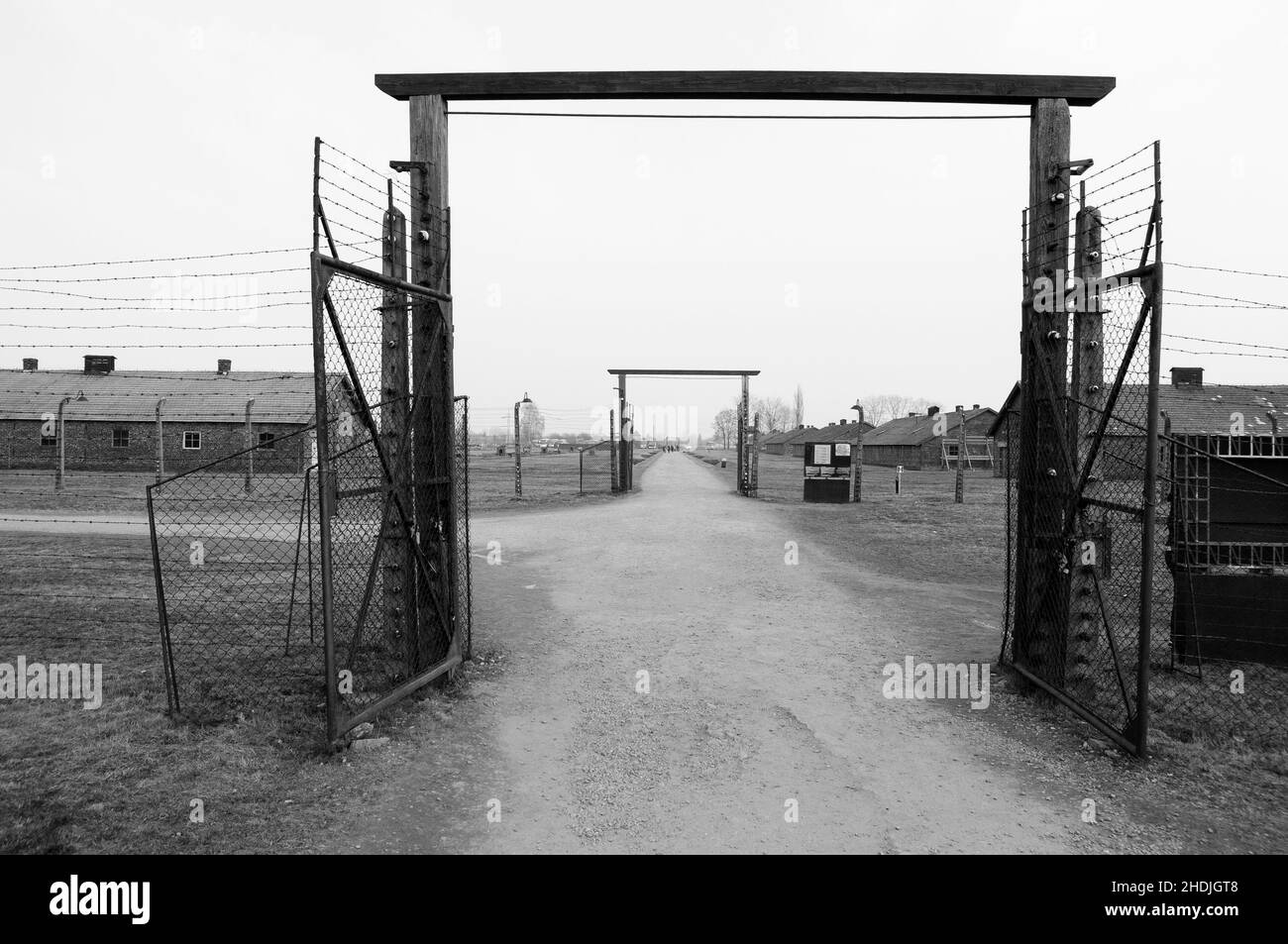 AUSCHWITZ, POLAND - March 30 2012 Melancholic view on open gates in concentration camp surrounded by barbed wire. Very soft and vintage looking. Stock Photo