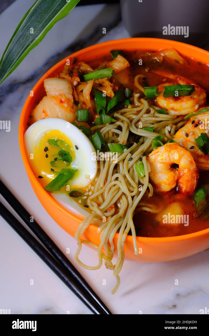 Korean kimchi and shrimp ramen garnished with soft boiled egg and sliced green onion Stock Photo