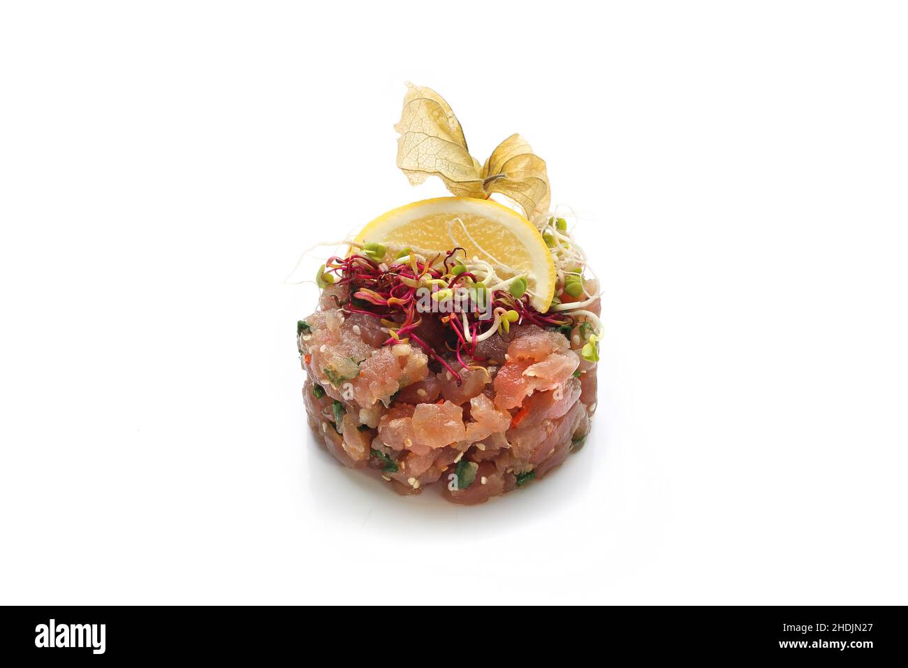Salmon tartare. Chopped salad with fresh fish and vegetables. Traditional Japanese dish on a white background. Stock Photo