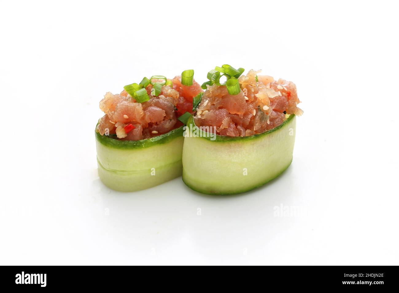Salmon tartare in a cucumber. Fresh chopped fish salad. Traditional Japanese dish on a white background. Stock Photo