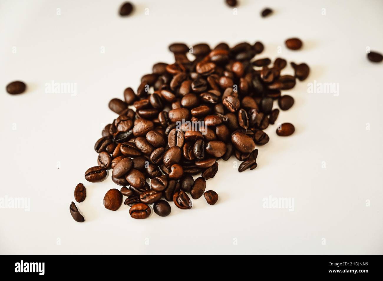 Brown roasted coffee beans on a pile with white background Stock Photo ...