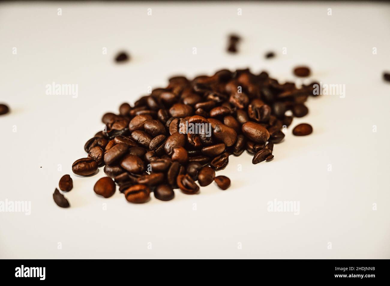 Brown roasted coffee beans on a pile with white background Stock Photo ...