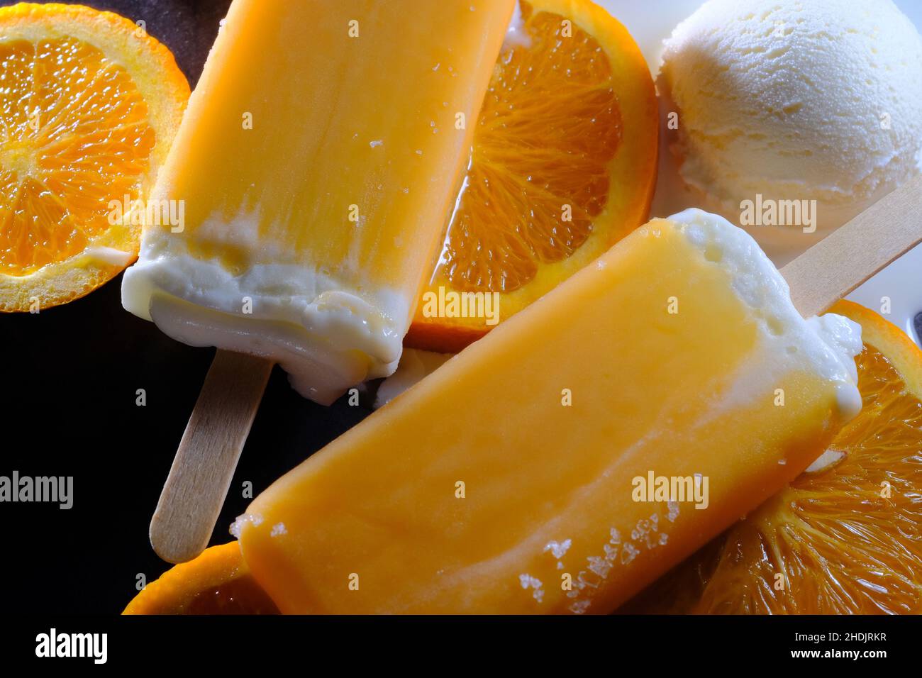 Oranges and cream vanilla ice pops melting on kitchen counter Stock