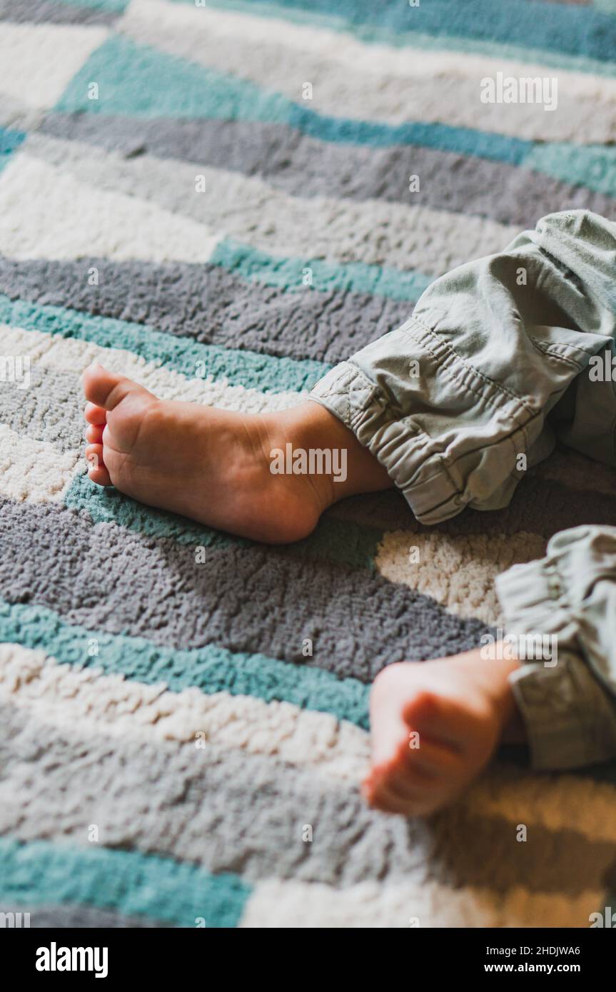 Vertical closeup shot of cute baby feet on a carpet Stock Photo Alamy
