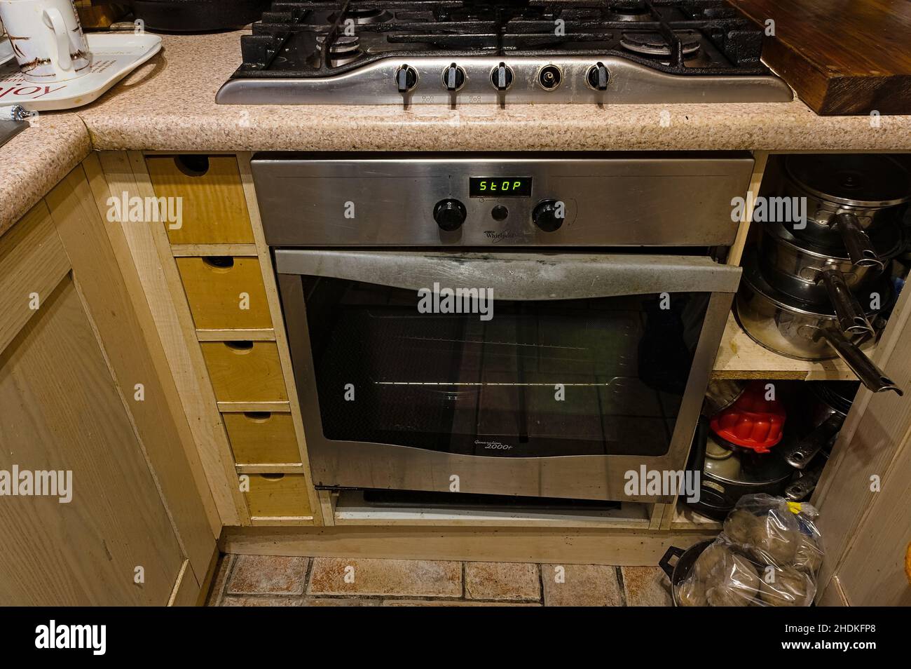 Built in Whirlpool oven with broken door and missing control knob in a home kitchen Stock Photo