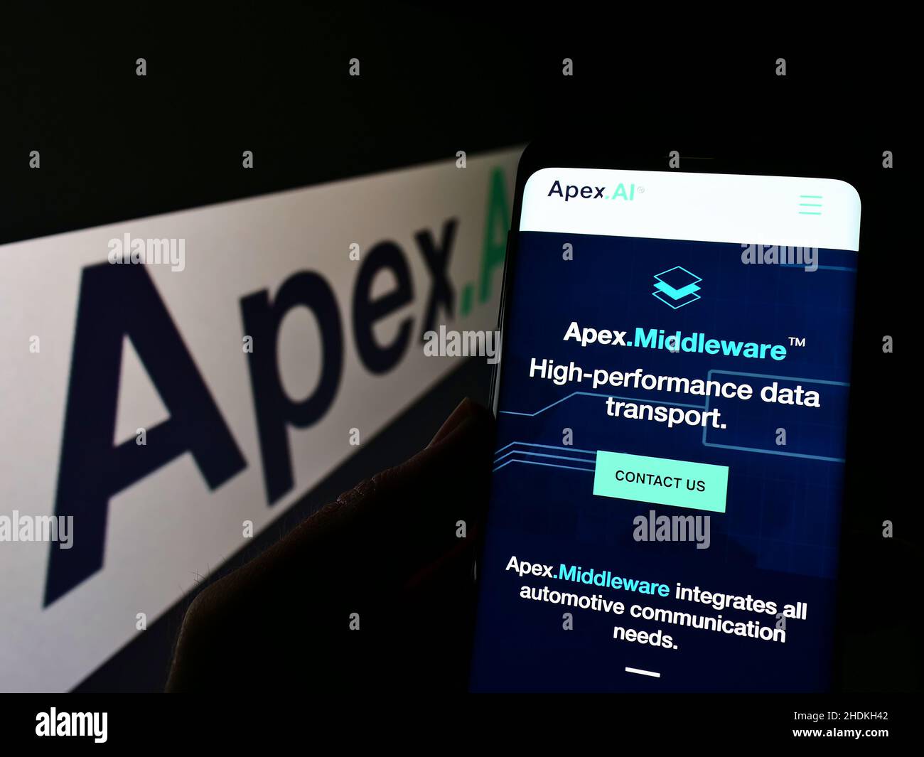Person holding smartphone with webpage of American autonomous driving company Apex.AI Inc. on screen with logo. Focus on center of phone display. Stock Photo