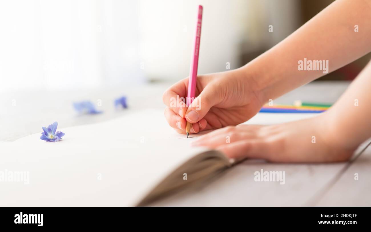 Girl drawing with pencil on a paper Stock Photo
