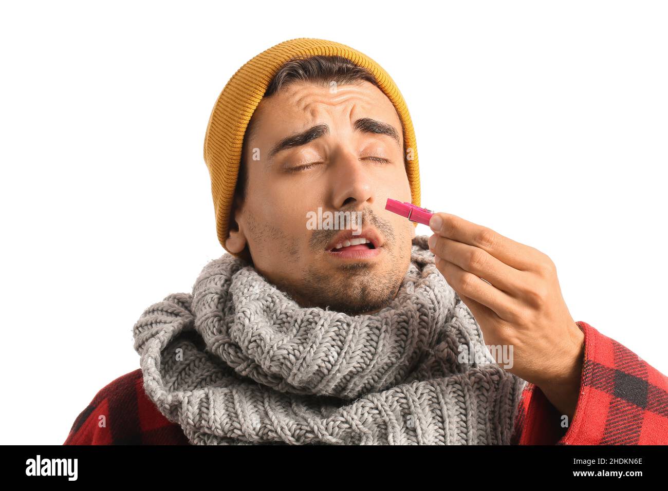 Ill young man with clothespin on white background. Stuffy nose concept