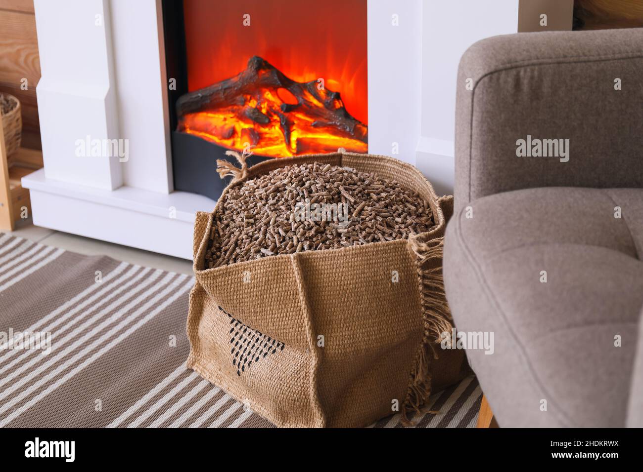 Bag with wood pellets near fireplace in living room Stock Photo - Alamy