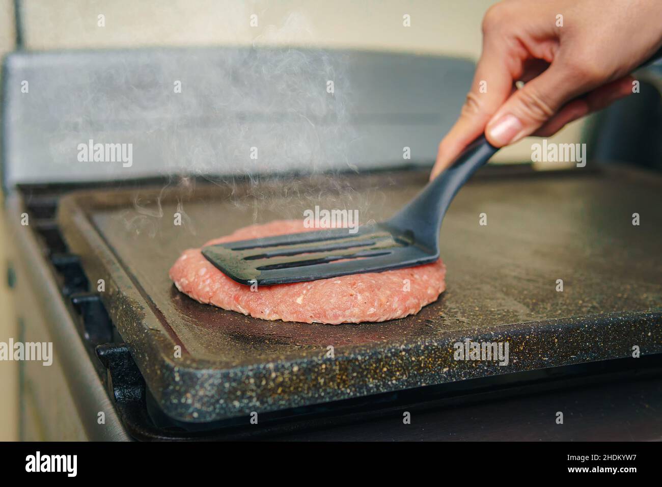 Close-up of a grill where hamburger meat is cooked, beef is cooking, nice atmosphere in the kitchen. Stock Photo
