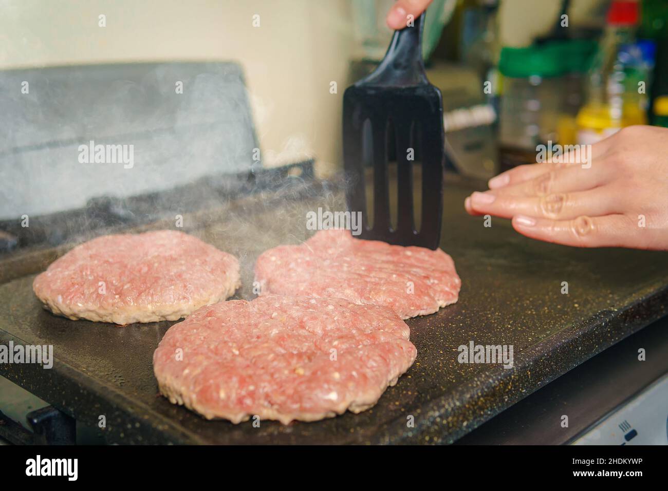 Close-up of a grill where hamburger meat is cooked, beef is cooking, nice atmosphere in the kitchen. Stock Photo