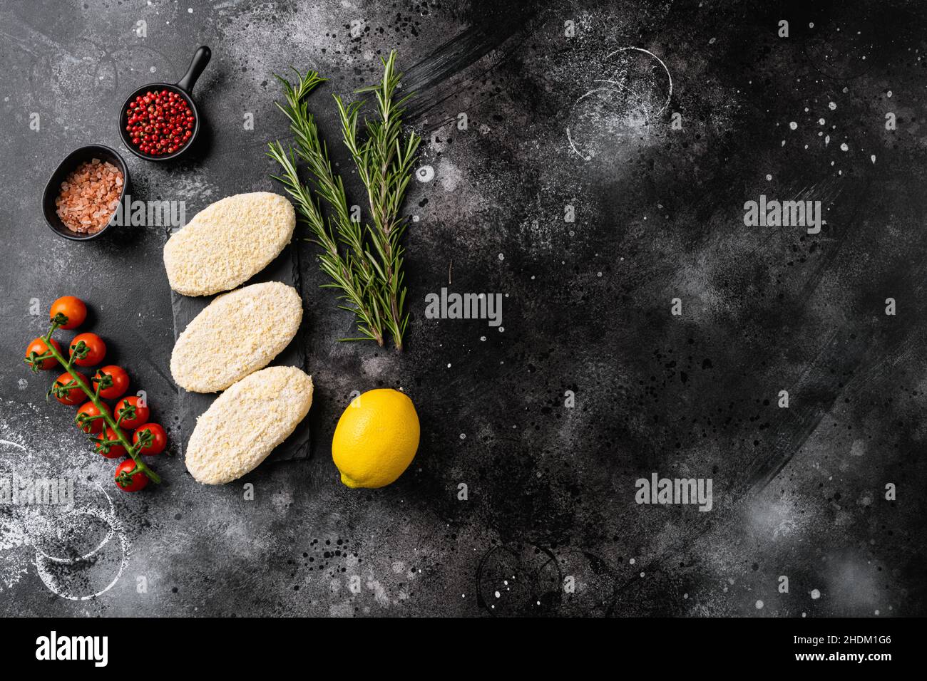 Frozen uncooked fishcake set, on black dark stone table background, top ...