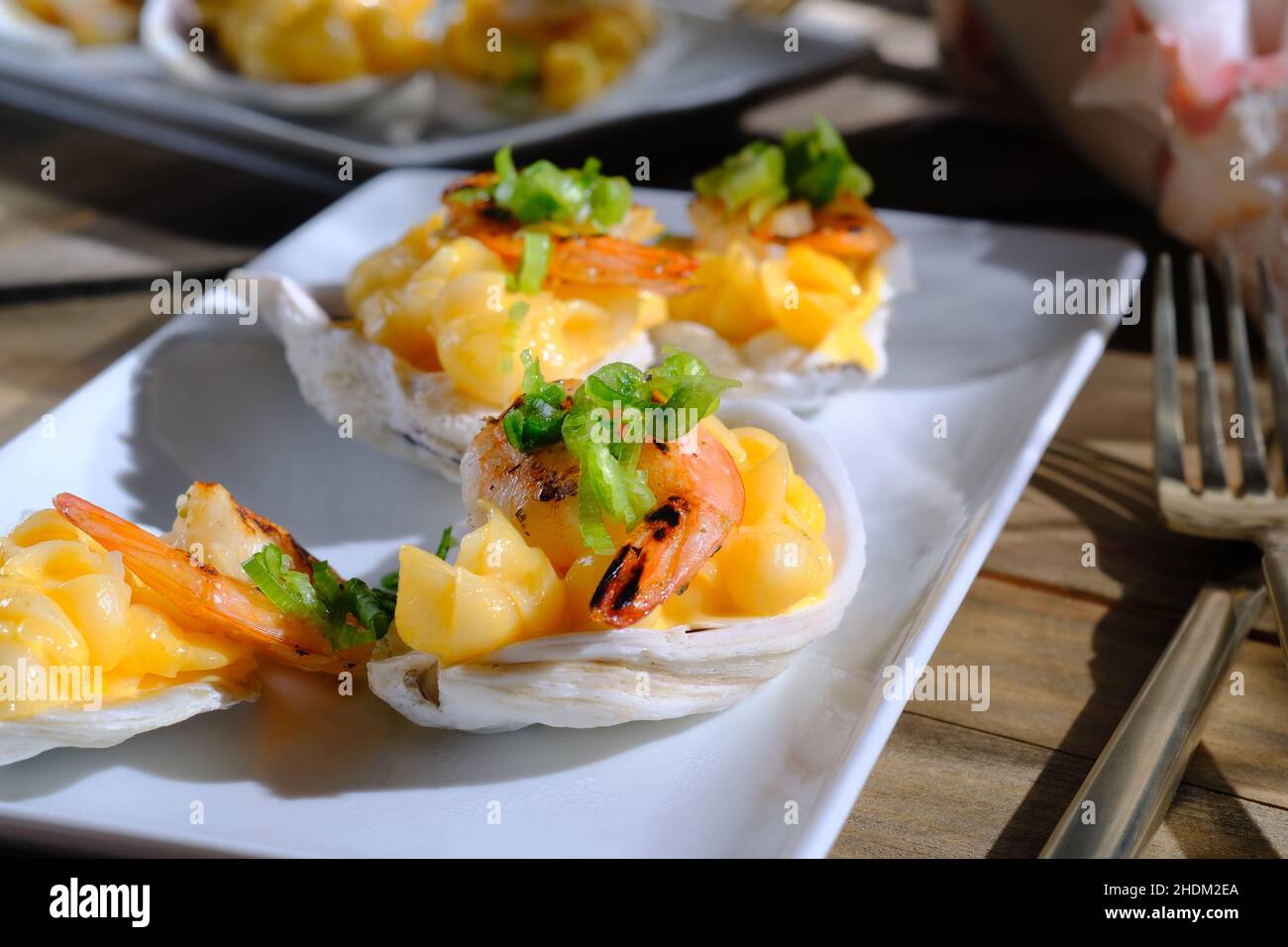 Fancy wedding Hors d'oeuvres shrimp mac and cheese served in oyster shell Stock Photo