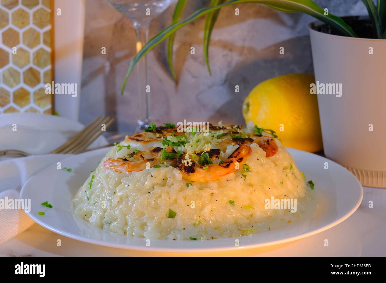 Fancy Italian shrimp risotto dinner served with a glass of fine pinot grigio Stock Photo
