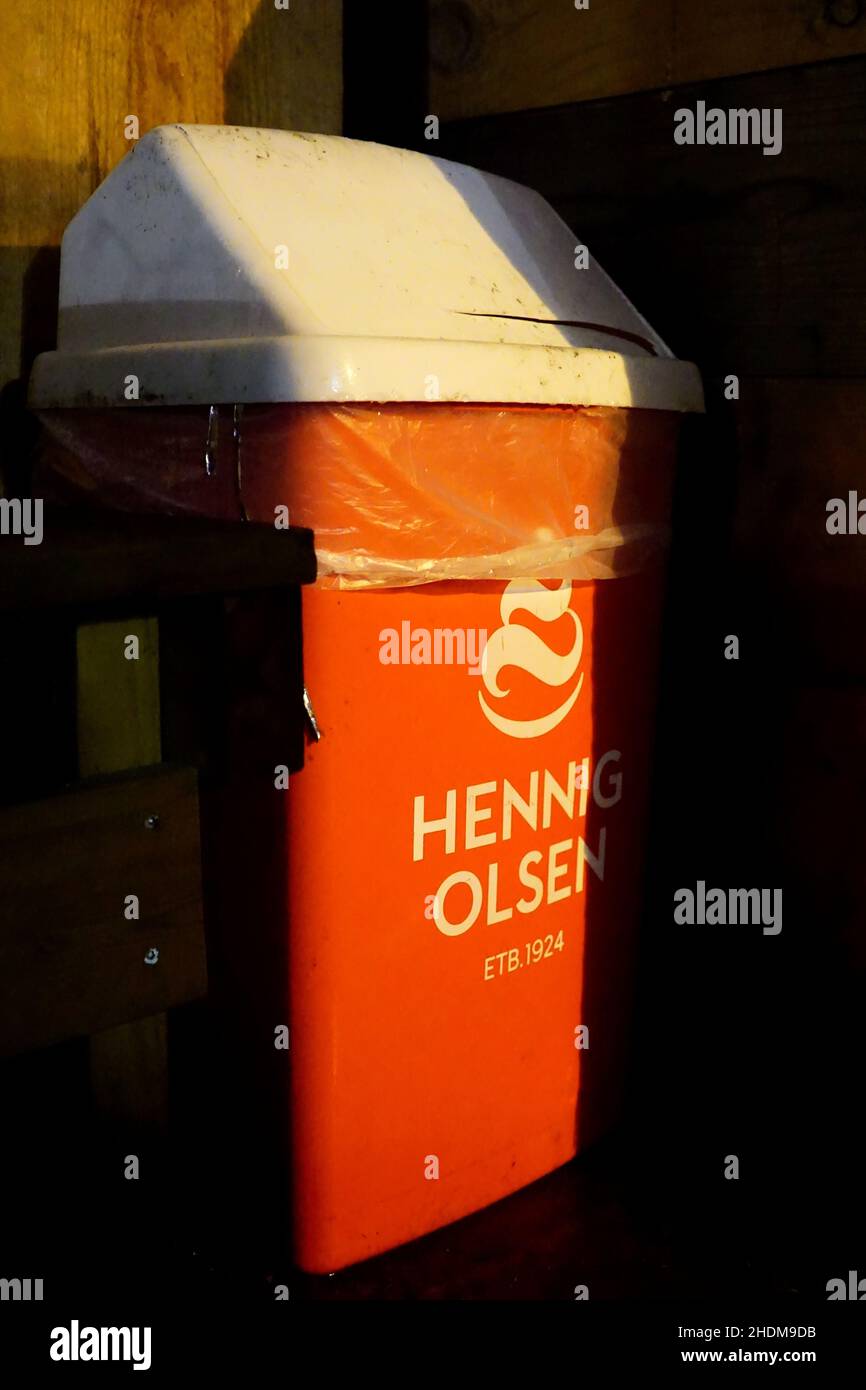 Orange and white trash can, waste bin with logo on from norwegian ice-cream maker Hennig-Olsen. Stock Photo